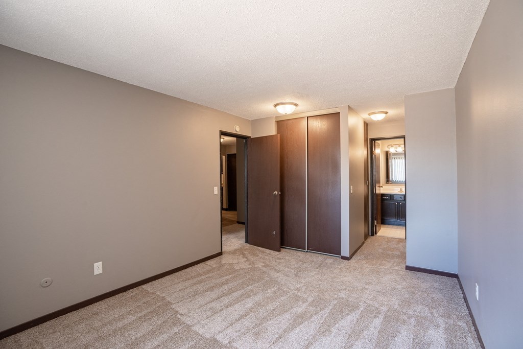 a bedroom with a closet and a bathroom