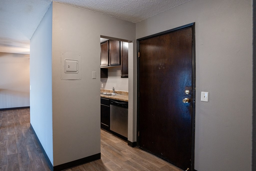 an open door leading into a kitchen with a sink and a refrigerator. Roseville, MN Rosedale Estates Apartments
