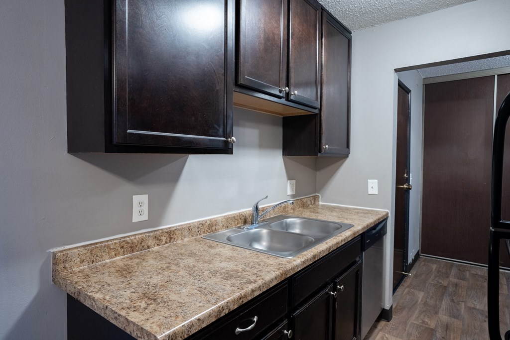 a kitchen with dark wood cabinets. Roseville, MN Rosedale Estates Apartments