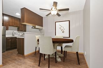 a dining area with a table and chairs and a kitchen in the background - Photo Gallery 5