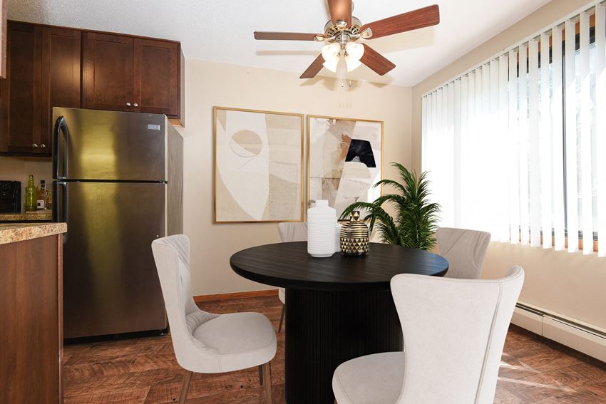 St Louis Park, MN Edge of Uptown Apartments | Furnished Dining Room a dining room in st louis park at the edge of uptown with a 4 chair table and a kitchen in the background - Photo Gallery