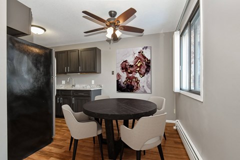 a dining room in st louis park at the edge of uptown with a 4 chair table and a kitchen in the background