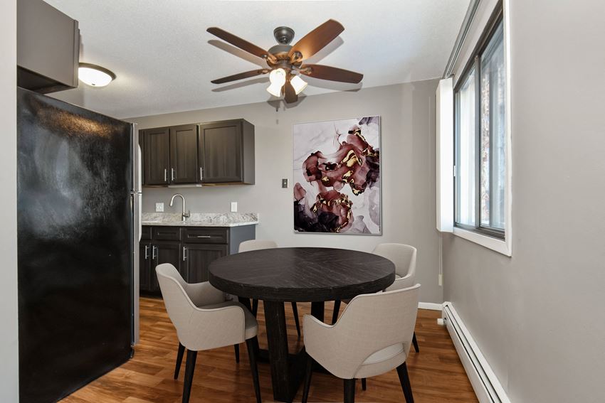St Louis Park, MN Edge of Uptown Apartments| Furnished Dining Room a dining room in st louis park at the edge of uptown with a 4 chair table and a kitchen in the background - Photo Gallery