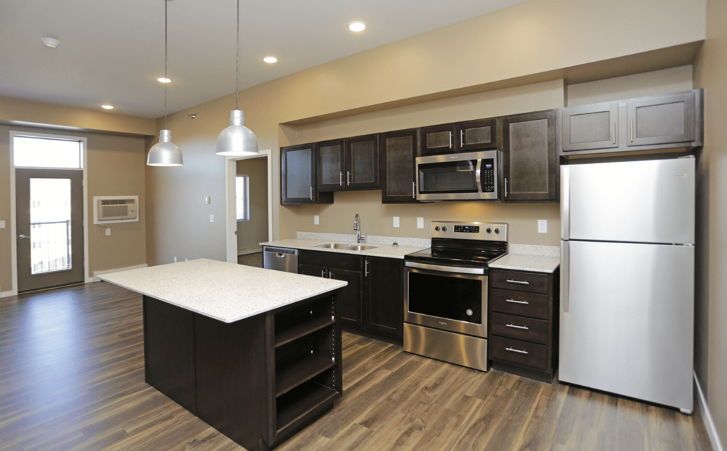 A kitchen with a refrigerator, oven, and microwave. Fargo, ND 29 West Apartments