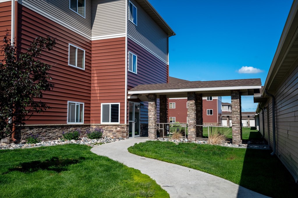 a sidewalk leading to a building with a covered walkway