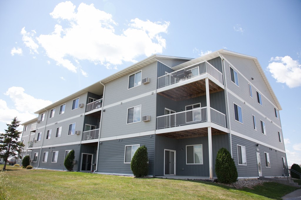 West Fargo, ND West Lake Apartments | Exterior An exterior view of a gray apartment building with balconies. West Fargo, ND West Lake Apartments.