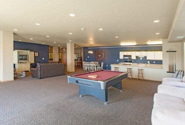 A community room with a pool table in the middle. West Fargo, ND West Lake Apartments.