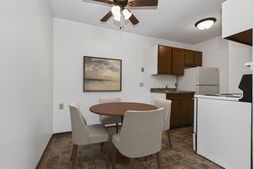 West St. Paul, MN Covington Courts Apartments | Dining Room a dining area in west st paul at Covington apartments with a table and 4 chairs and a kitchen in the background