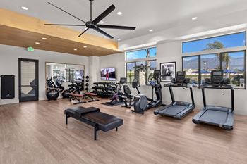 a gym with a lot of exercise equipment and windowsat Westbury Apartments, Rancho Cucamonga, 91739