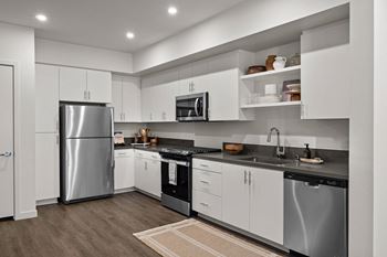 a kitchen with white cabinets and stainless steel appliancesat Westbury Apartments, Rancho Cucamonga, California
