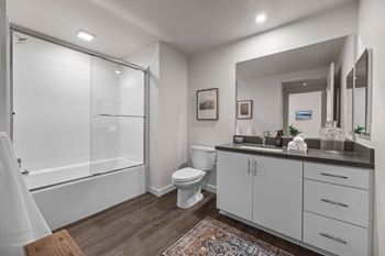 a bathroom with a shower toilet and sink and a mirror at Westbury Apartments, Rancho Cucamonga, CA, 91739