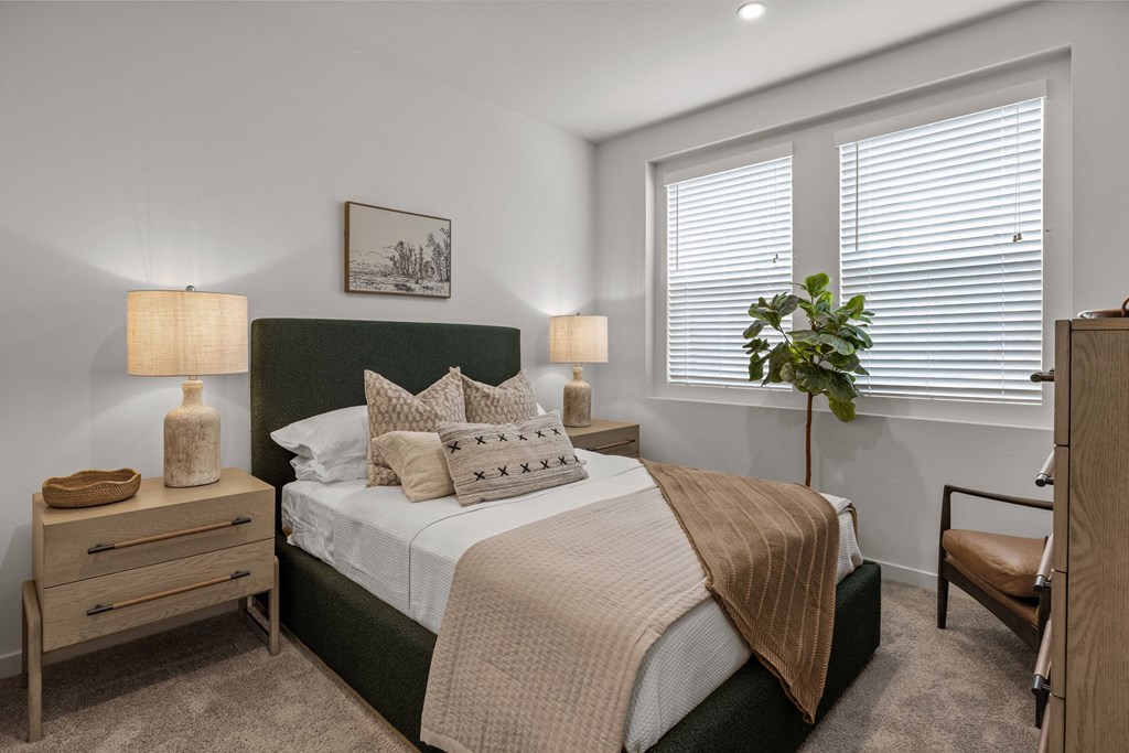 an empty bedroom with a bed and two windowsat Westbury Apartments, Rancho Cucamonga, CA, 91739