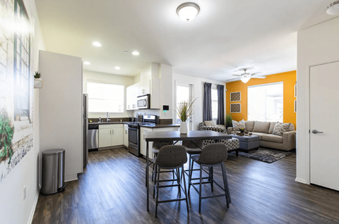 a living room and kitchen with a table and chairs