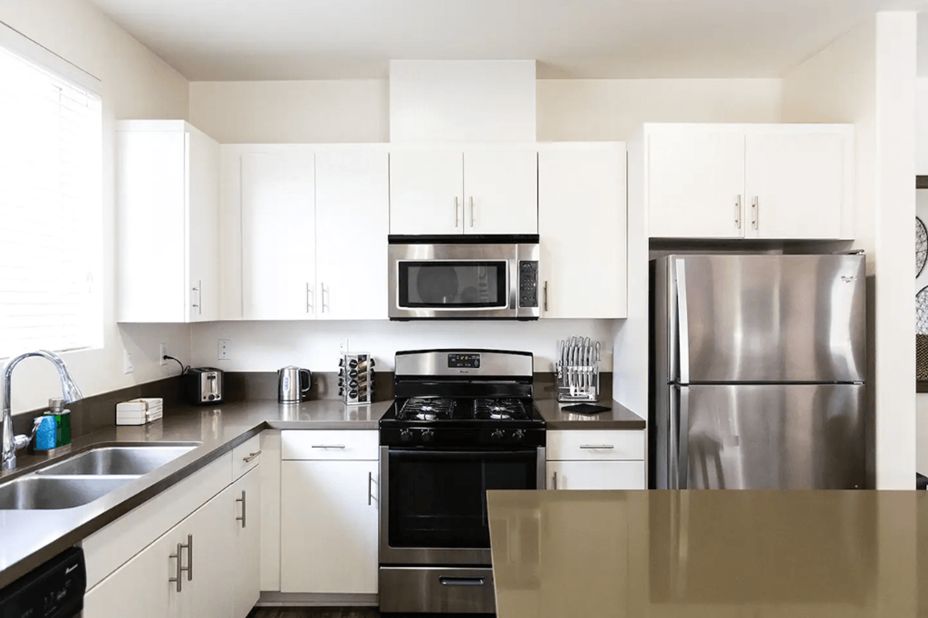 a kitchen with stainless steel appliances and white cabinets