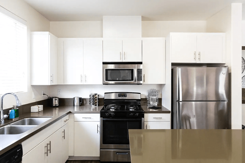 a kitchen with stainless steel appliances and white cabinets