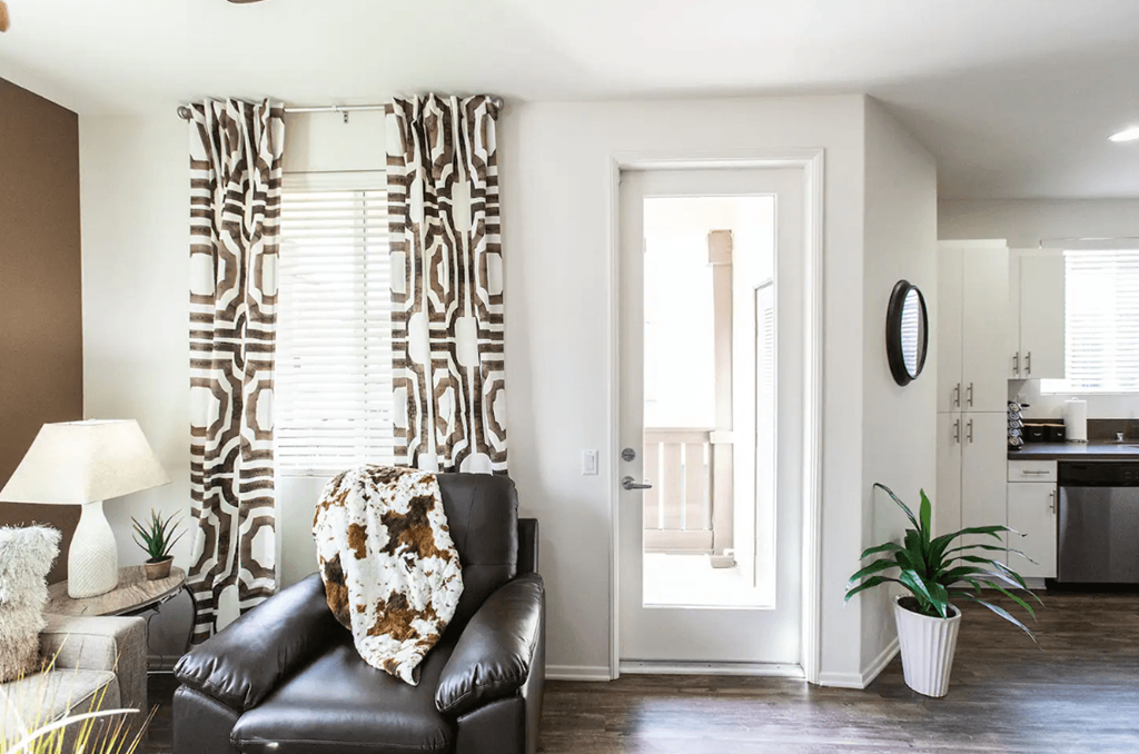a living room with a leather chair and curtains