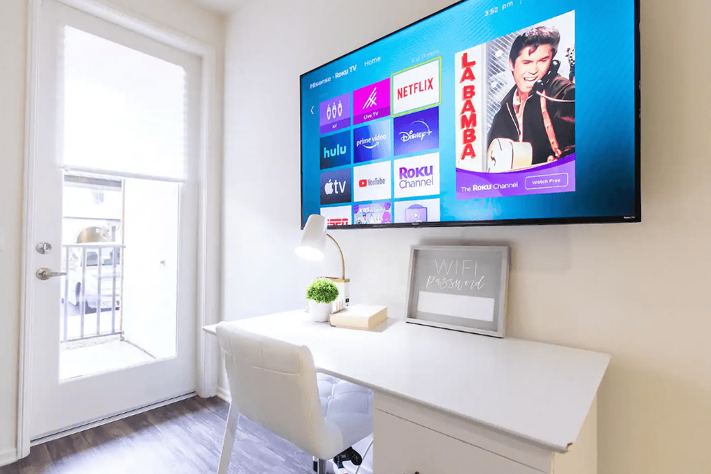 a home office with a desk and a tv on the wall