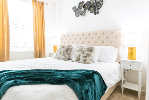 a bedroom with a large bed and a green blanket