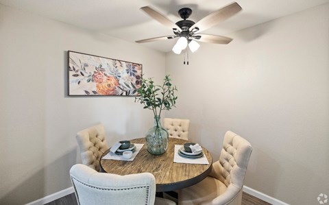 A dining room with a round table and chairs.