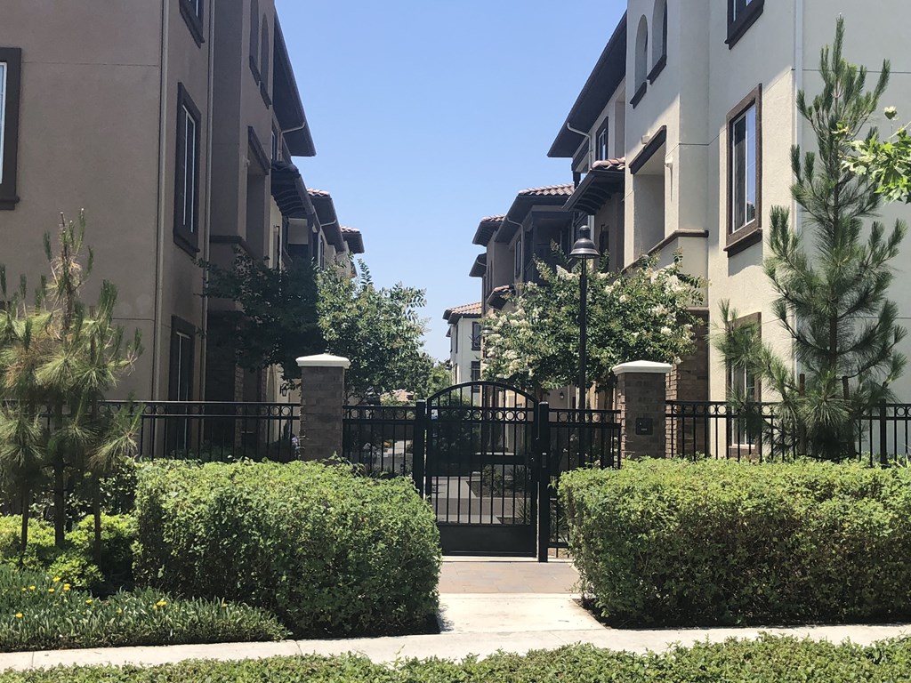 an apartment building with a gate and a sidewalk