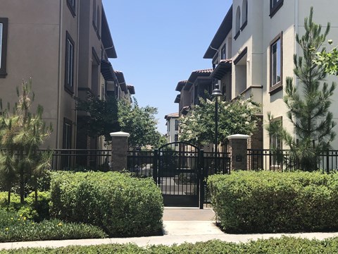an apartment building with a gate and a sidewalk
