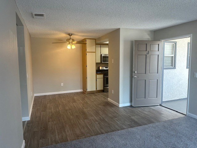 an empty living room and kitchen with a ceiling fanat Lincoln Park Apartments, Corona, CA 92882