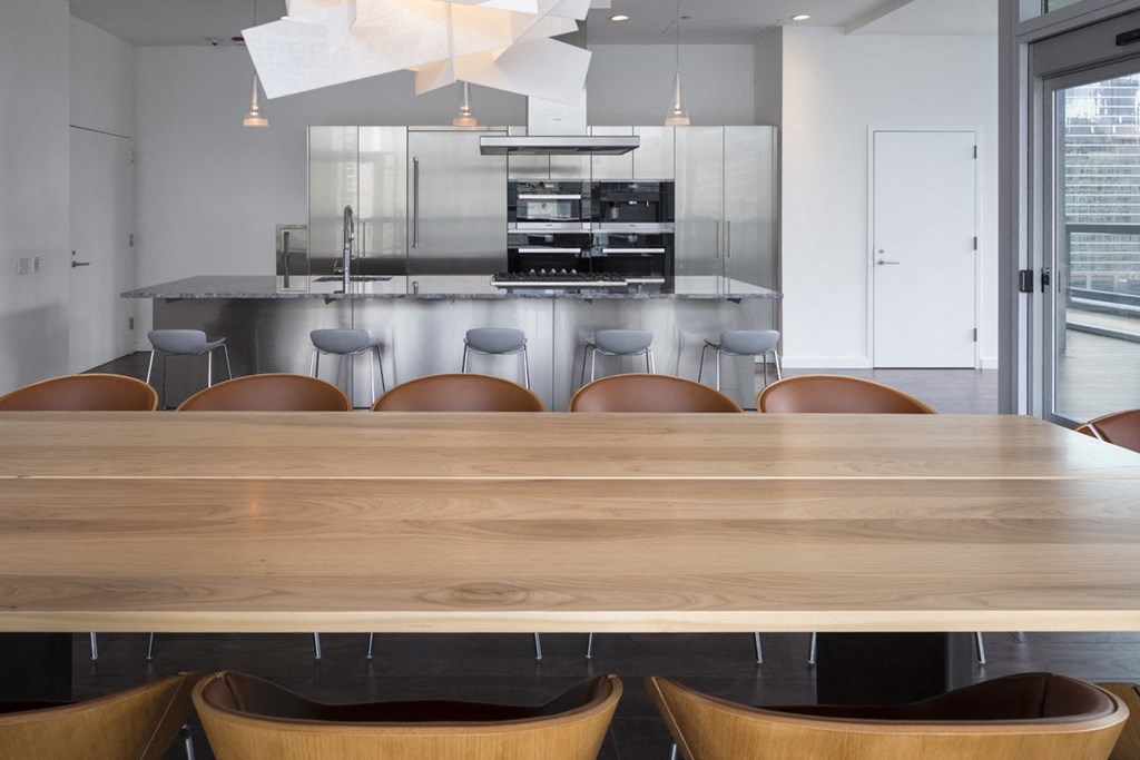 a dining room table with chairs in front of a kitchen