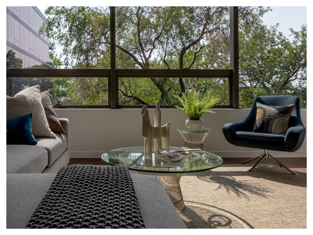 a living room with a large window and a couch and a table