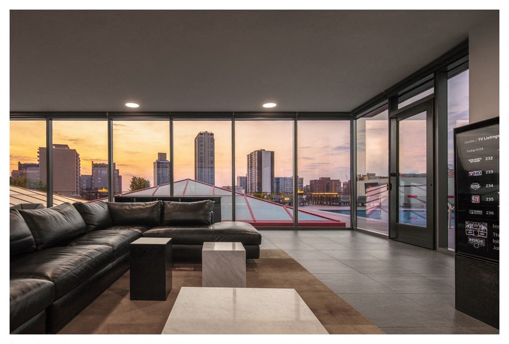 a living room with leather couches and a view of the city