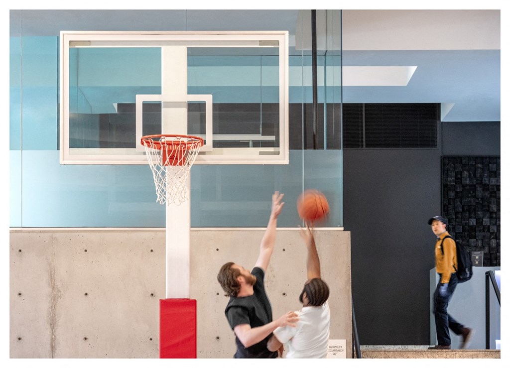 two young men playing basketball on a court