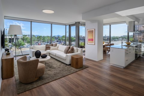 A modern living room with a white sofa and a wooden floor.