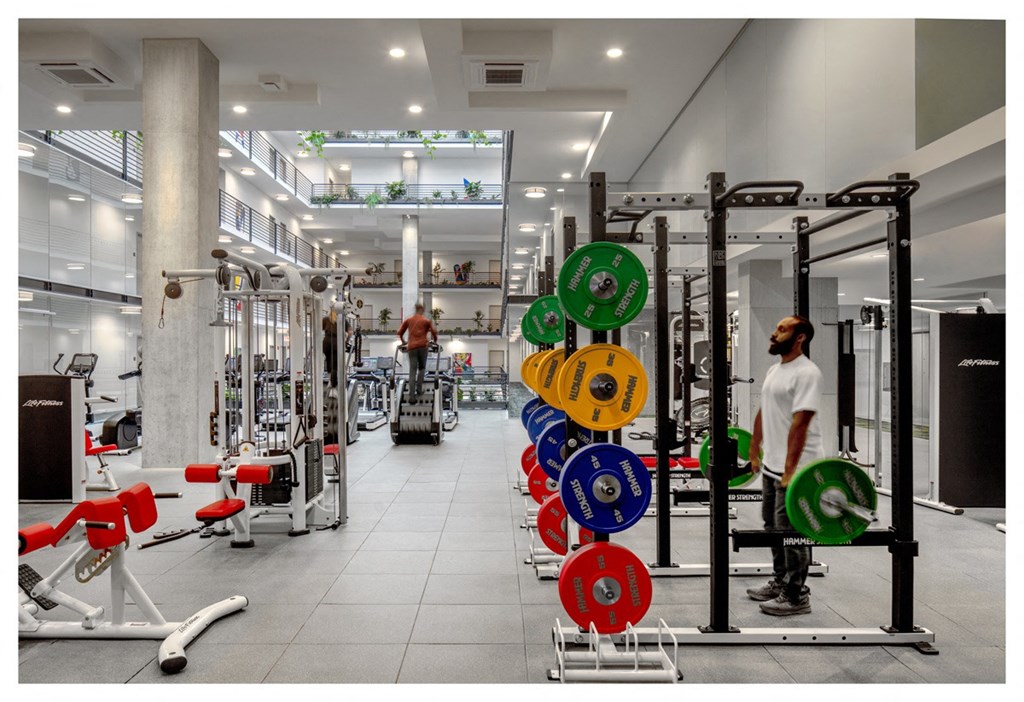 a view of the fitness center with weights machines and people in it