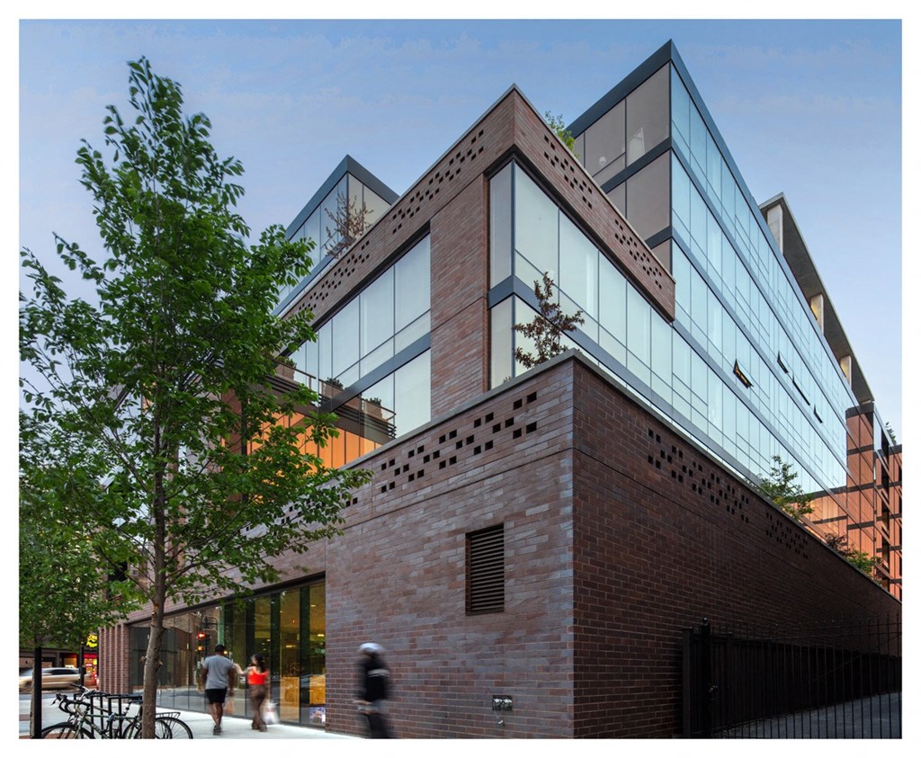 a view of the side of a building with people walking