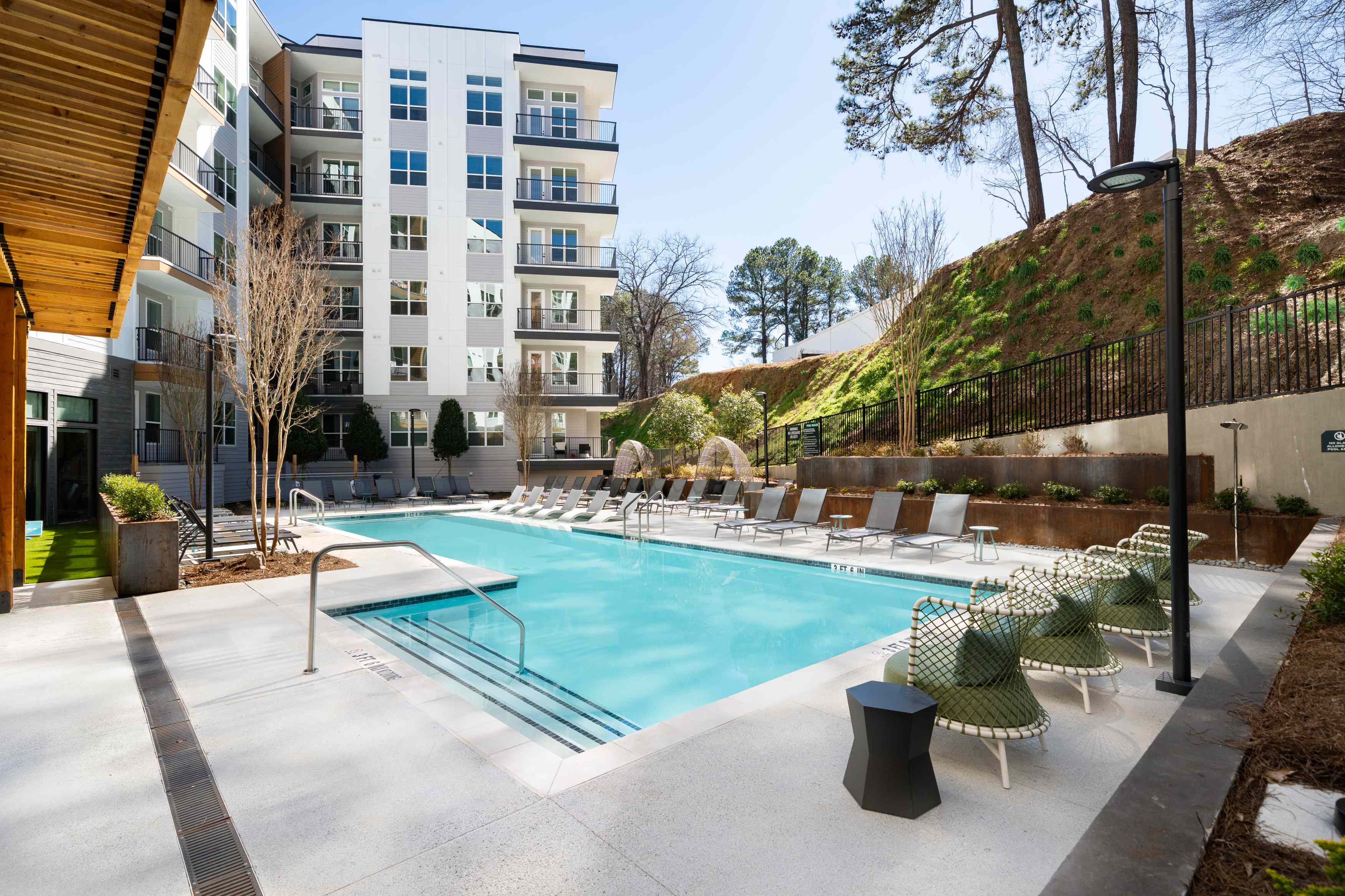 Outdoor pool with chairs and a view of the building