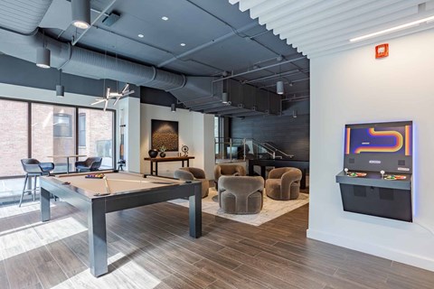 A room with a pool table and a TV on the wall.