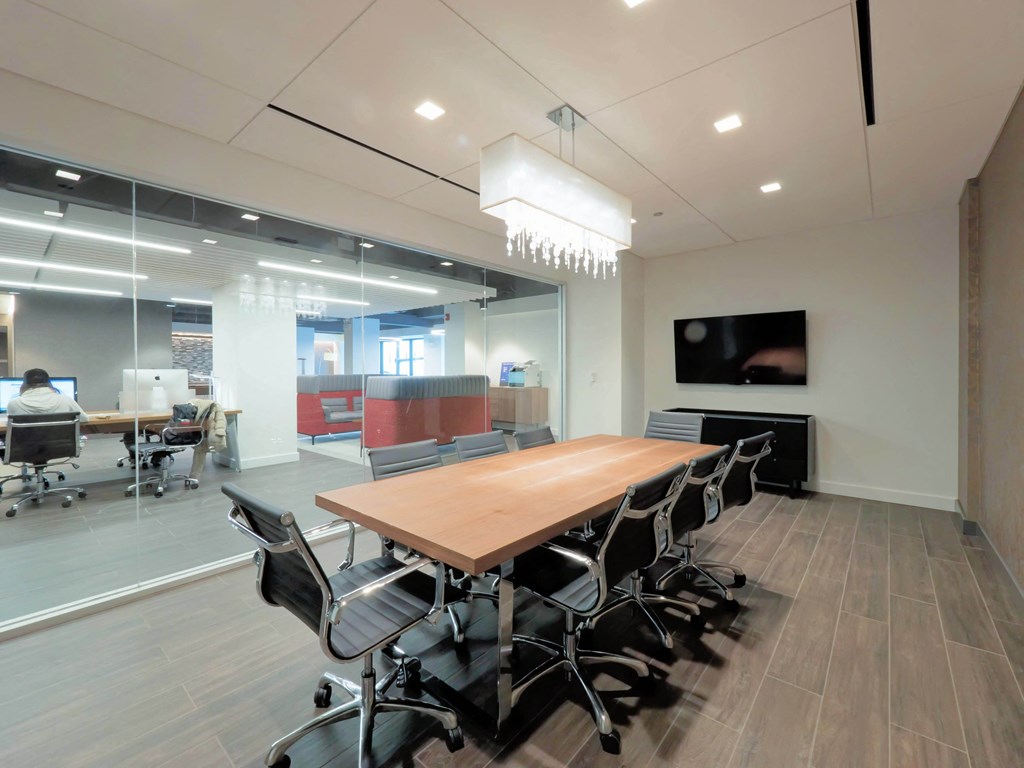 a conference room with a wooden table and chairs and a tv