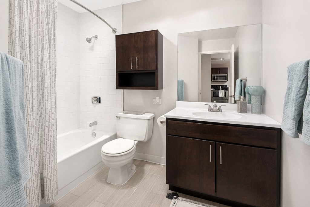 a bathroom with a toilet sink and tub and a mirror