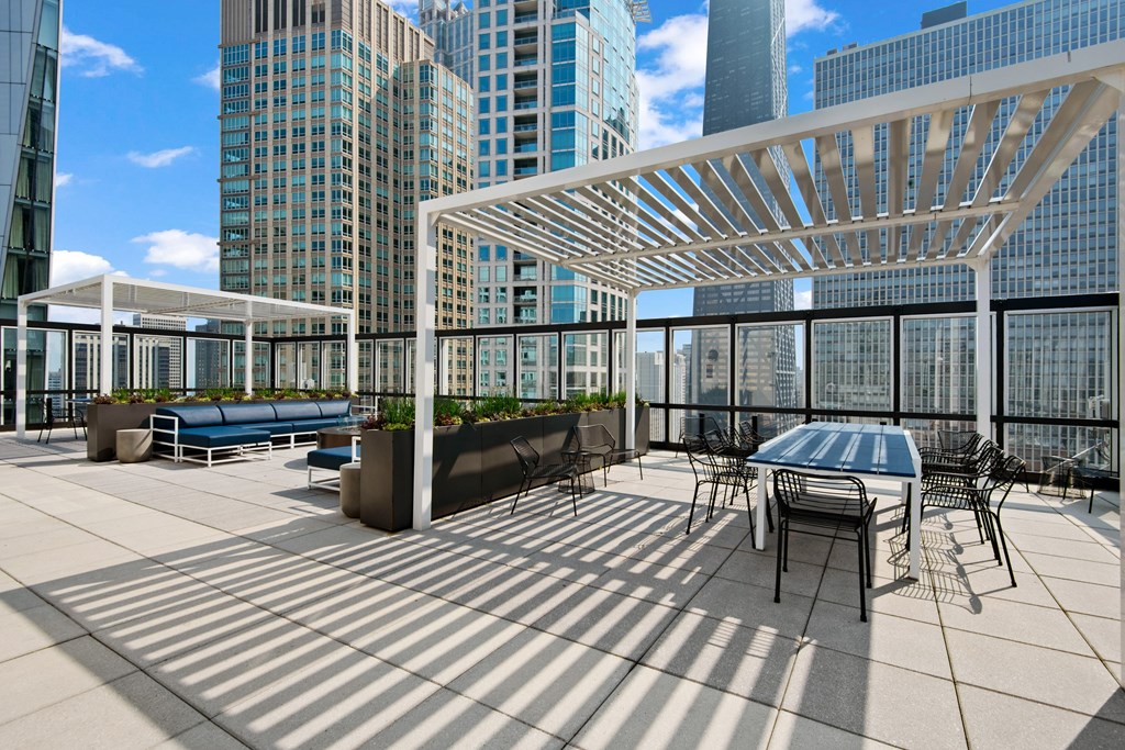 A rooftop patio with a table and chairs.