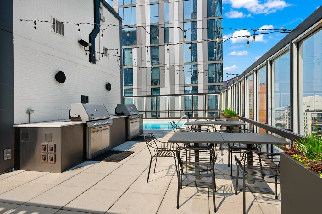 A patio with a table and chairs overlooking a pool.
