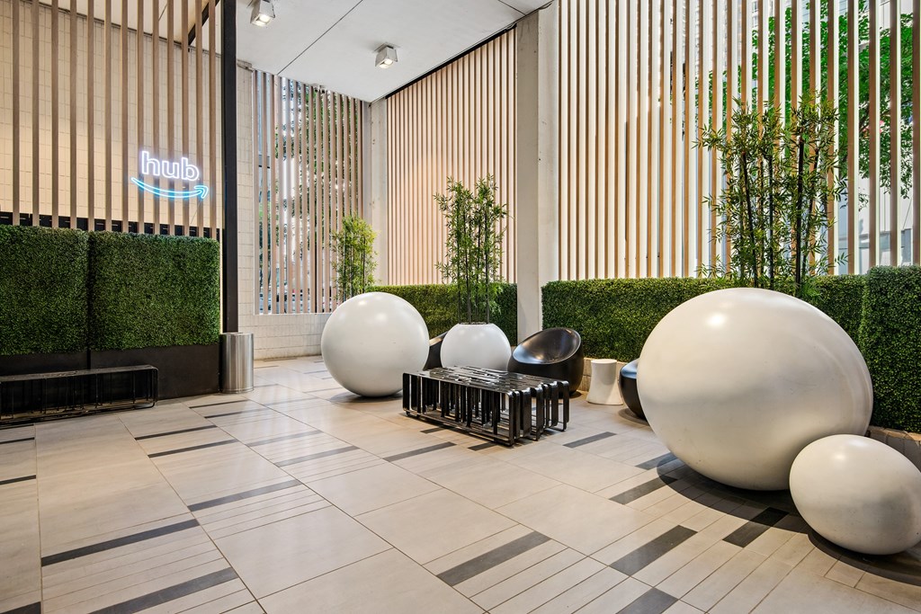 A modern lobby with white spherical objects and a green wall.