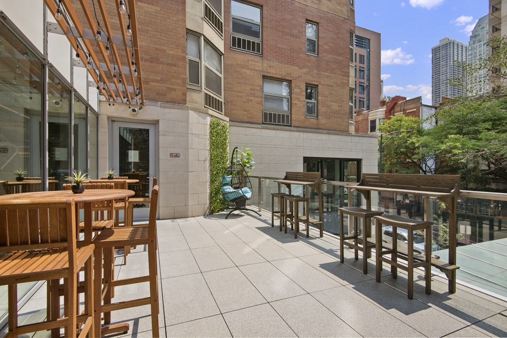 a patio with tables and chairs and a building in the background