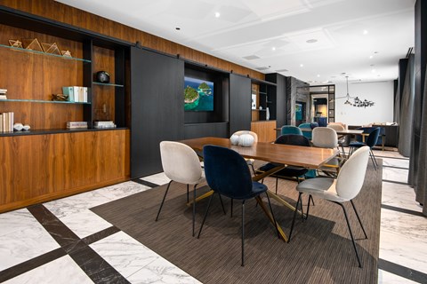 A modern dining room with a wooden table and chairs.