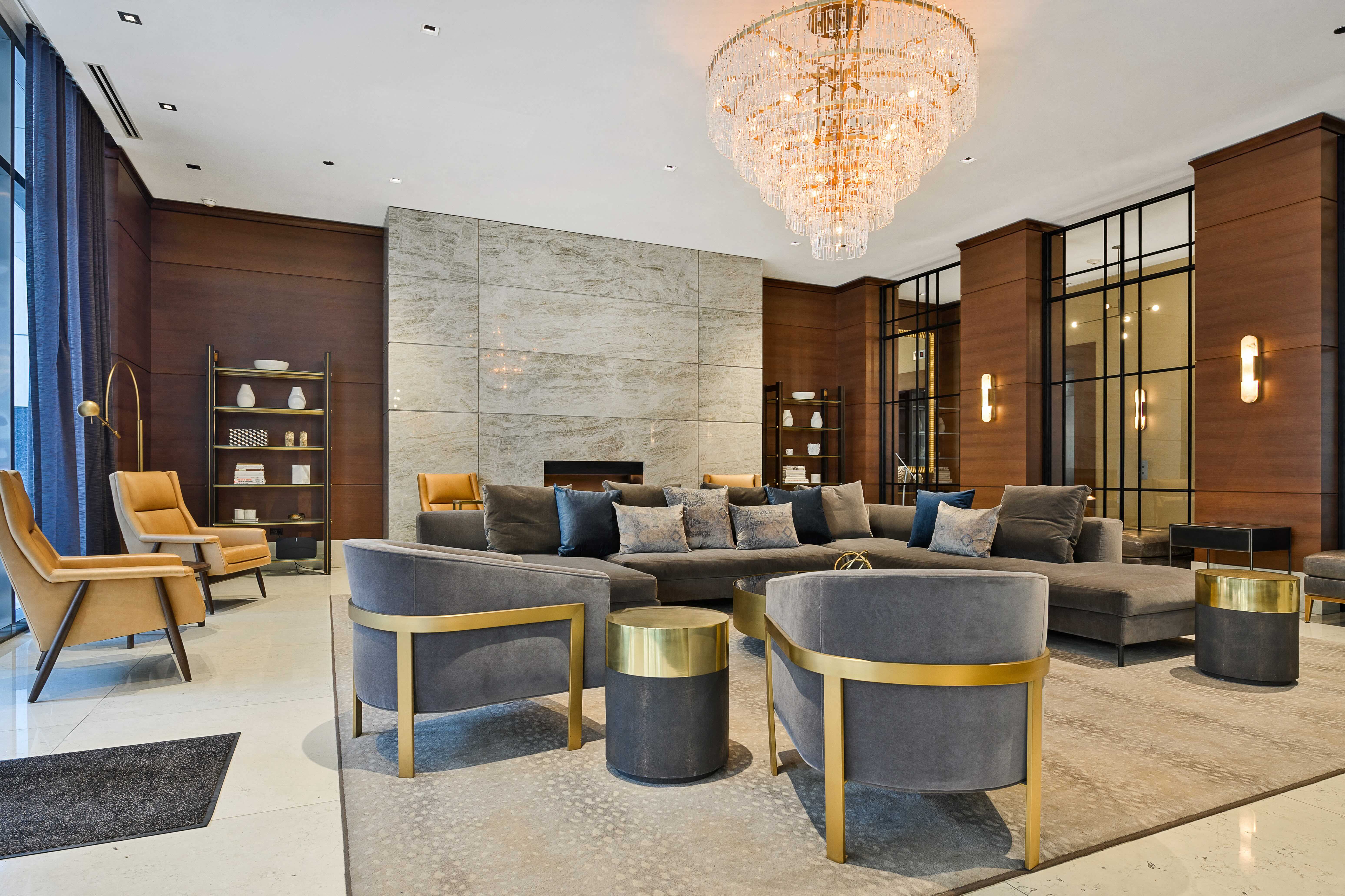 A modern living room with a grey sofa and a gold chandelier.