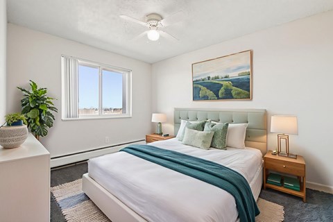 A bedroom with a large bed and a painting on the wall.