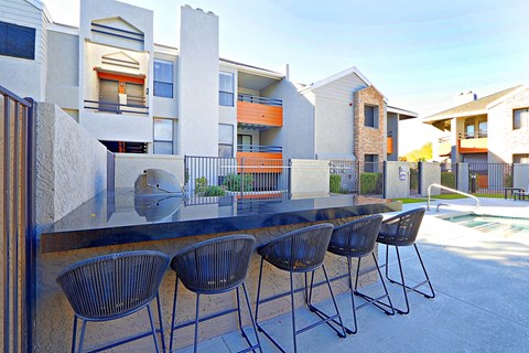 a patio with a table and chairs in front of some apartments
