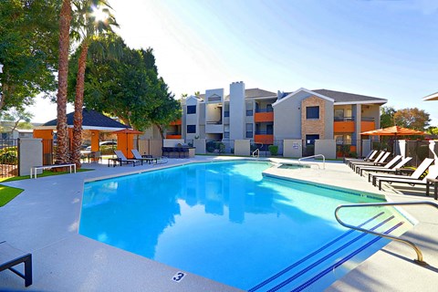 a swimming pool at the resort with apartments in the background