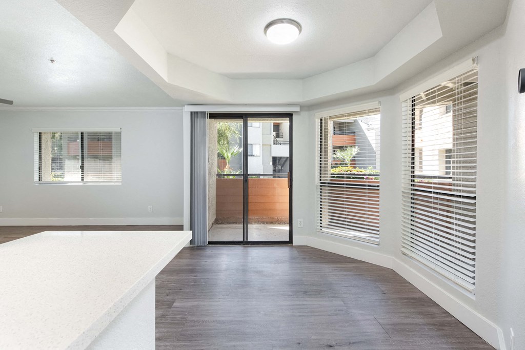 an empty living room with windows and a door to a patio