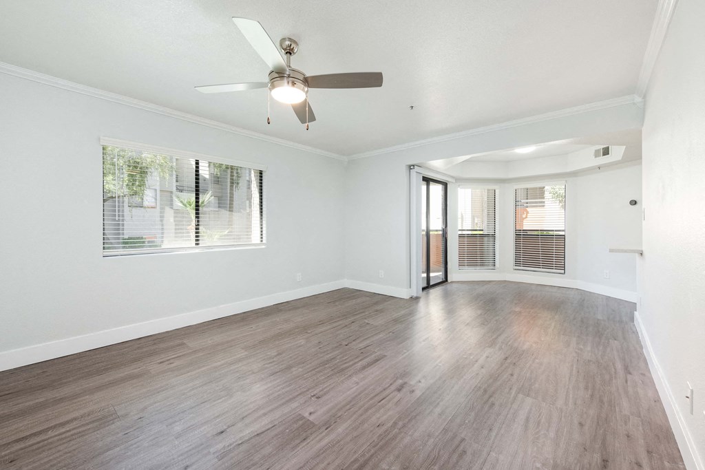 the living room of an empty house with a ceiling fan