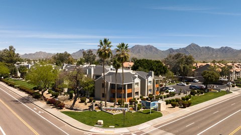 an aerial view of a building with palm trees and a street