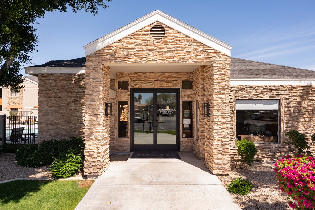 the front entrance of a brick building with glass doors